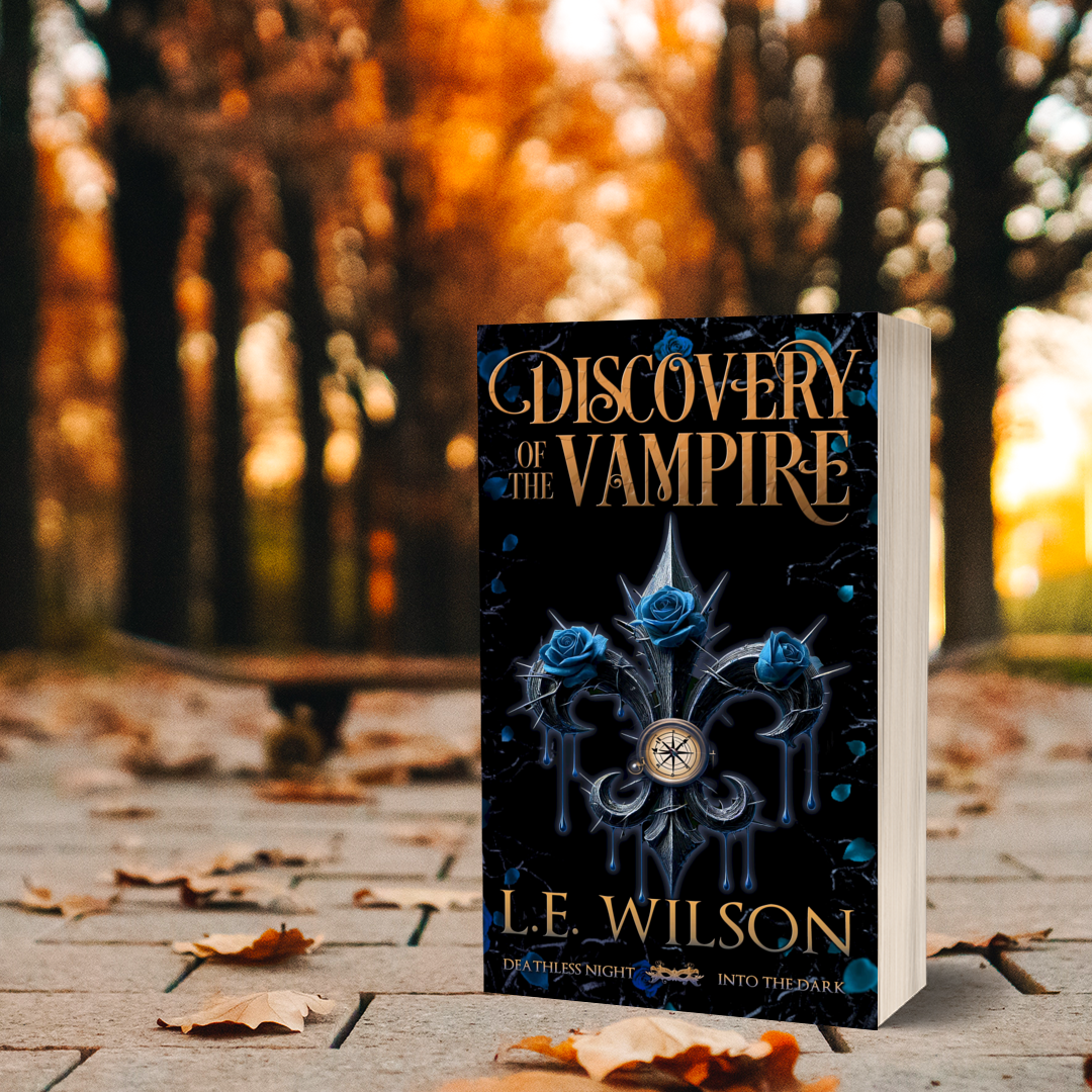 Book titled 'Discovery of the Vampire' by L.E. Wilson on a wooden surface with a blurred autumn background.