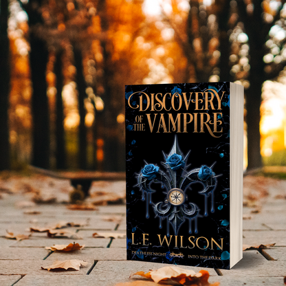 Book titled 'Discovery of the Vampire' by L.E. Wilson on a wooden surface with a blurred autumn background.