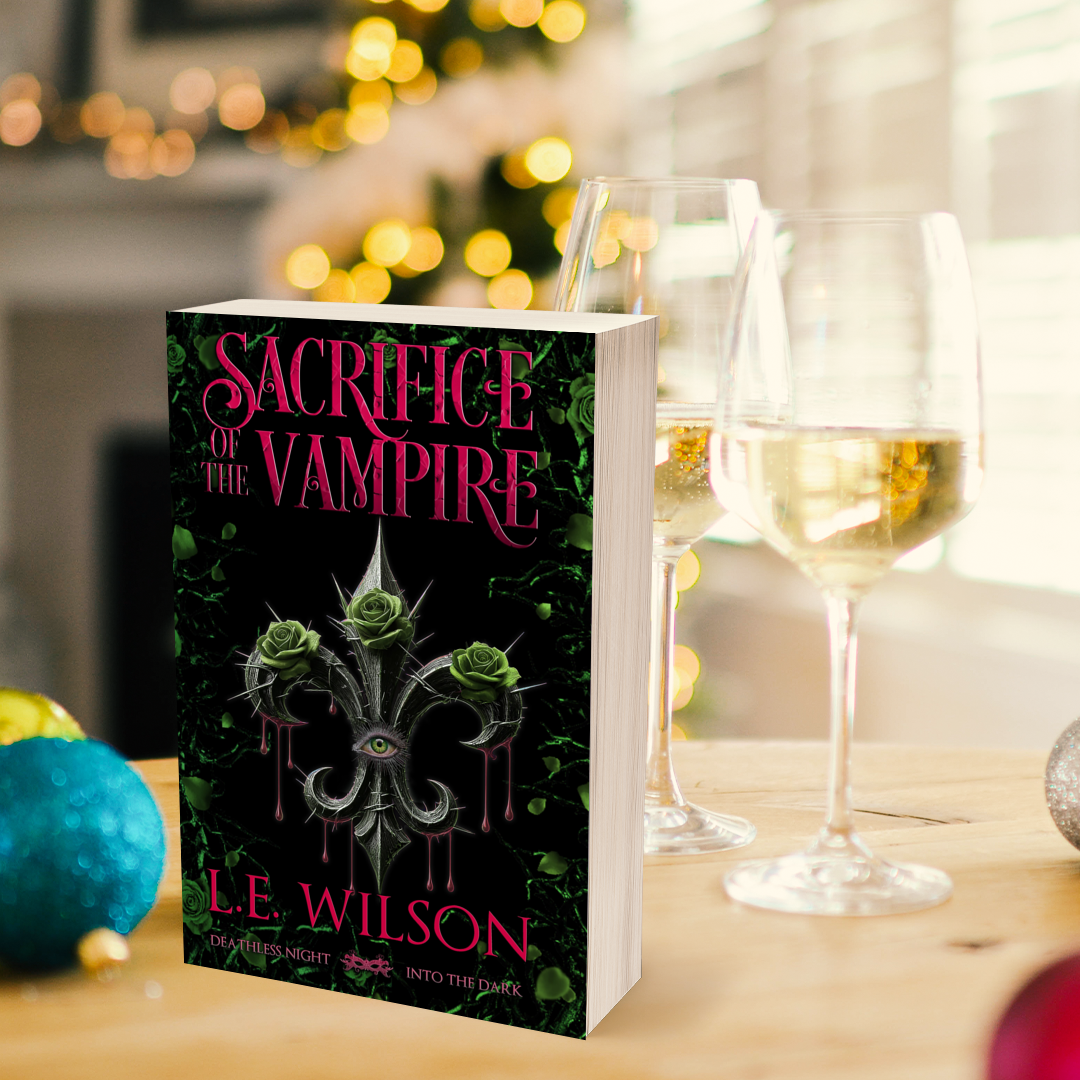 Book titled 'Sacrifice of the Vampire' by L.E. Wilson on a table with wine glasses. Paranormal Romance
